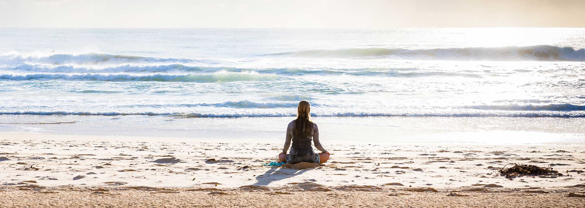 Woman meditating n beach